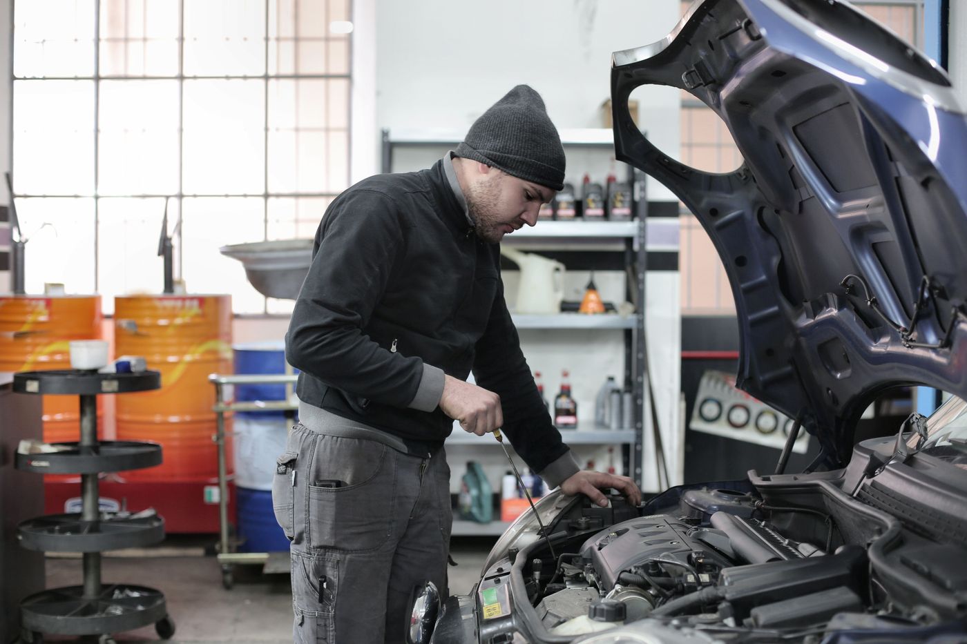 Mecanic lucrează în compartimentul motor al unei mașini